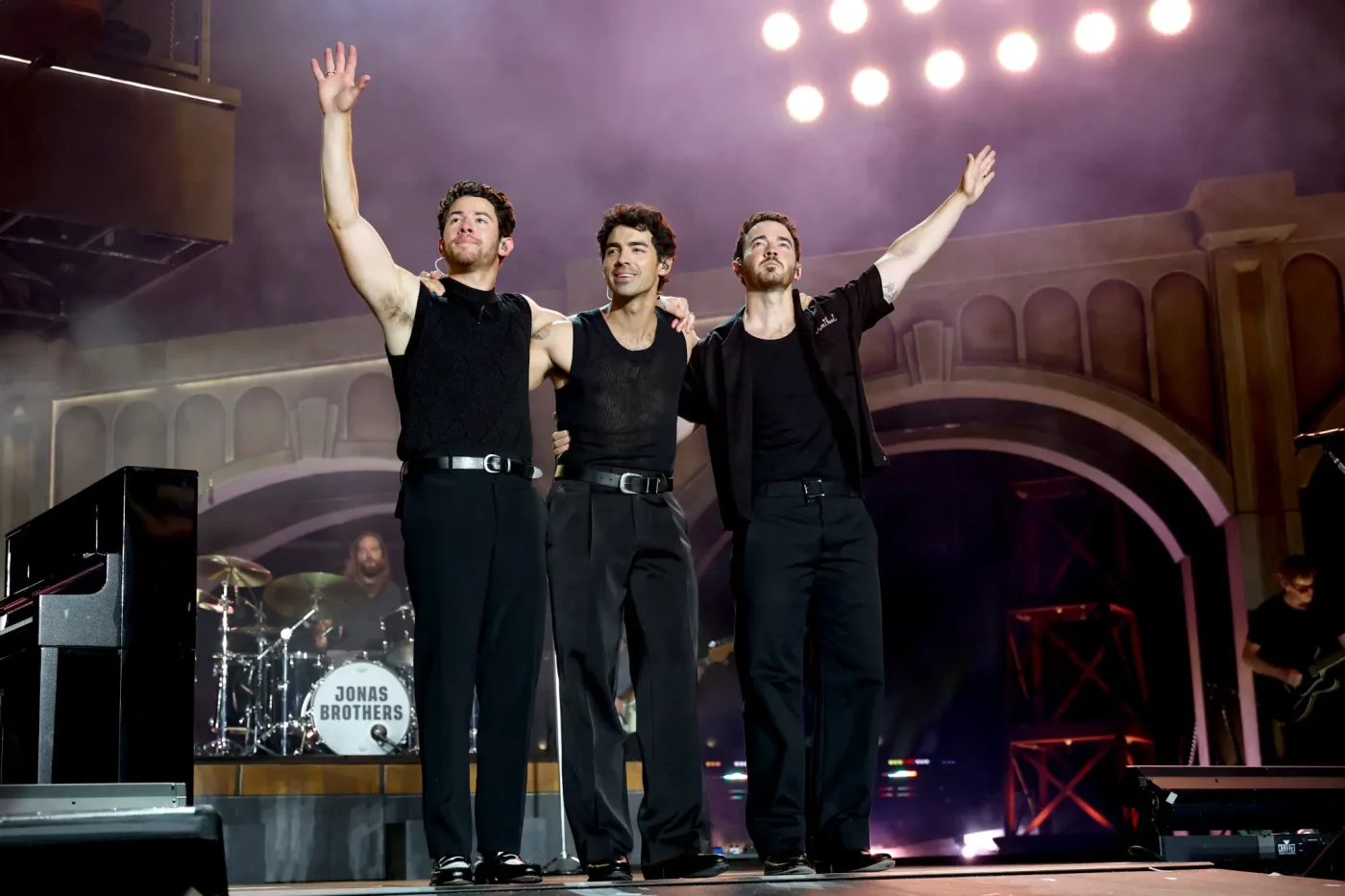 Nick Jonas, Joe Jonas, and Kevin Jonas perform onstage.