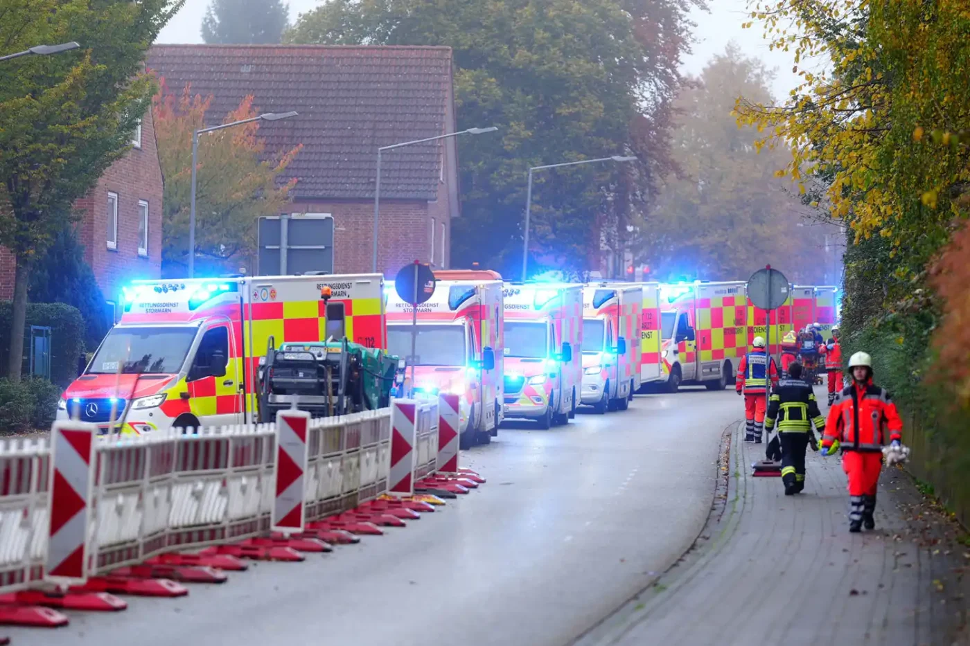 Numerous ambulances are lined up along a street. A school bus carrying about 20 children was involved in an accident this morning in Bad Oldesloe, Schleswig-Holstein, and crashed into the wall of a house. According to current information, several passengers and the bus driver were injured, police reported.