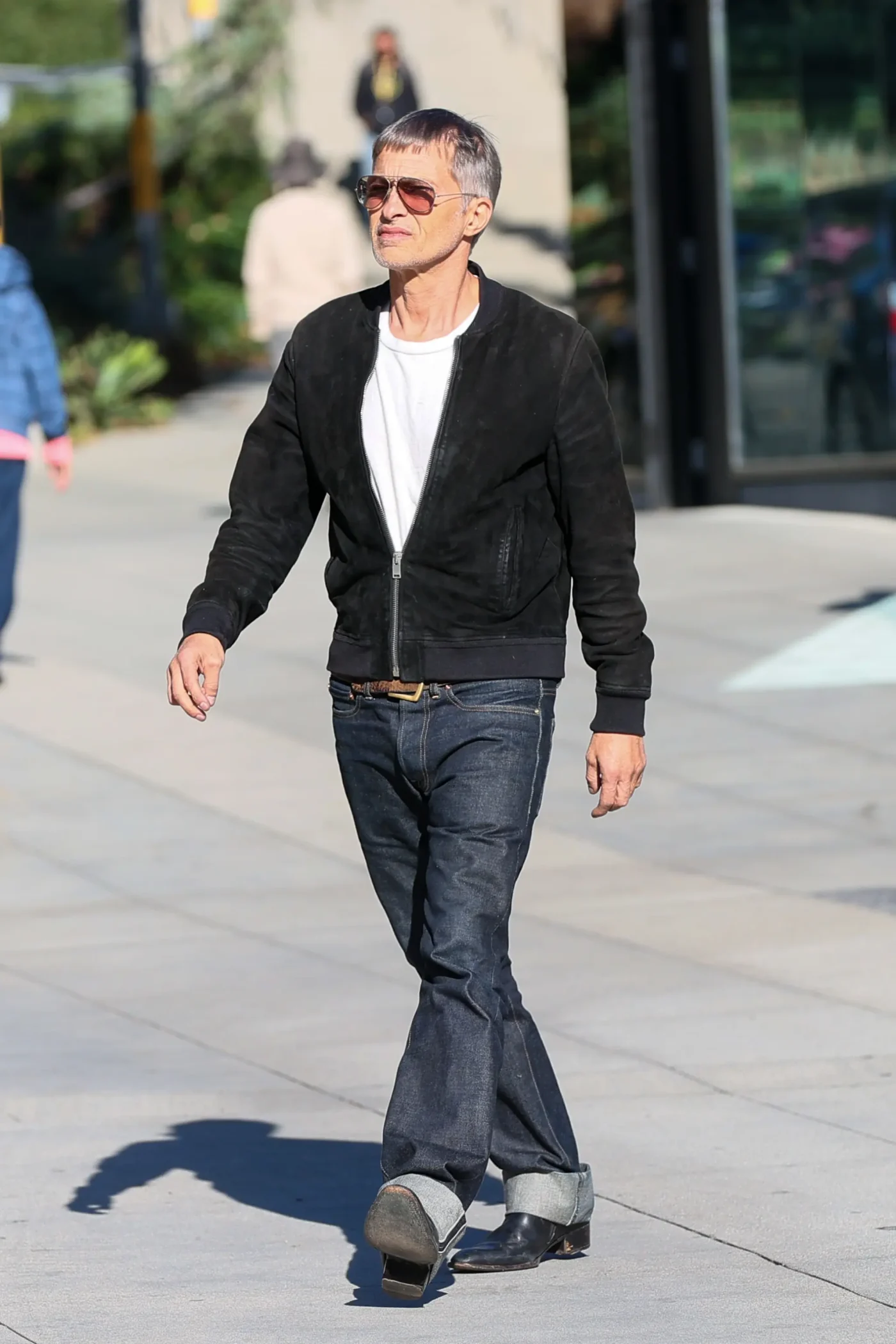Olivier Martinez walking on a sidewalk.