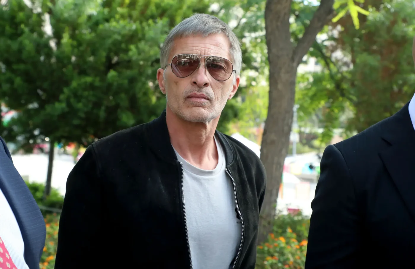 Olivier Martinez wearing sunglasses and a black jacket outdoors.