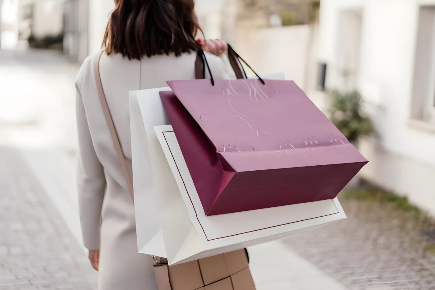 person carrying multiple shopping bags outdoors.