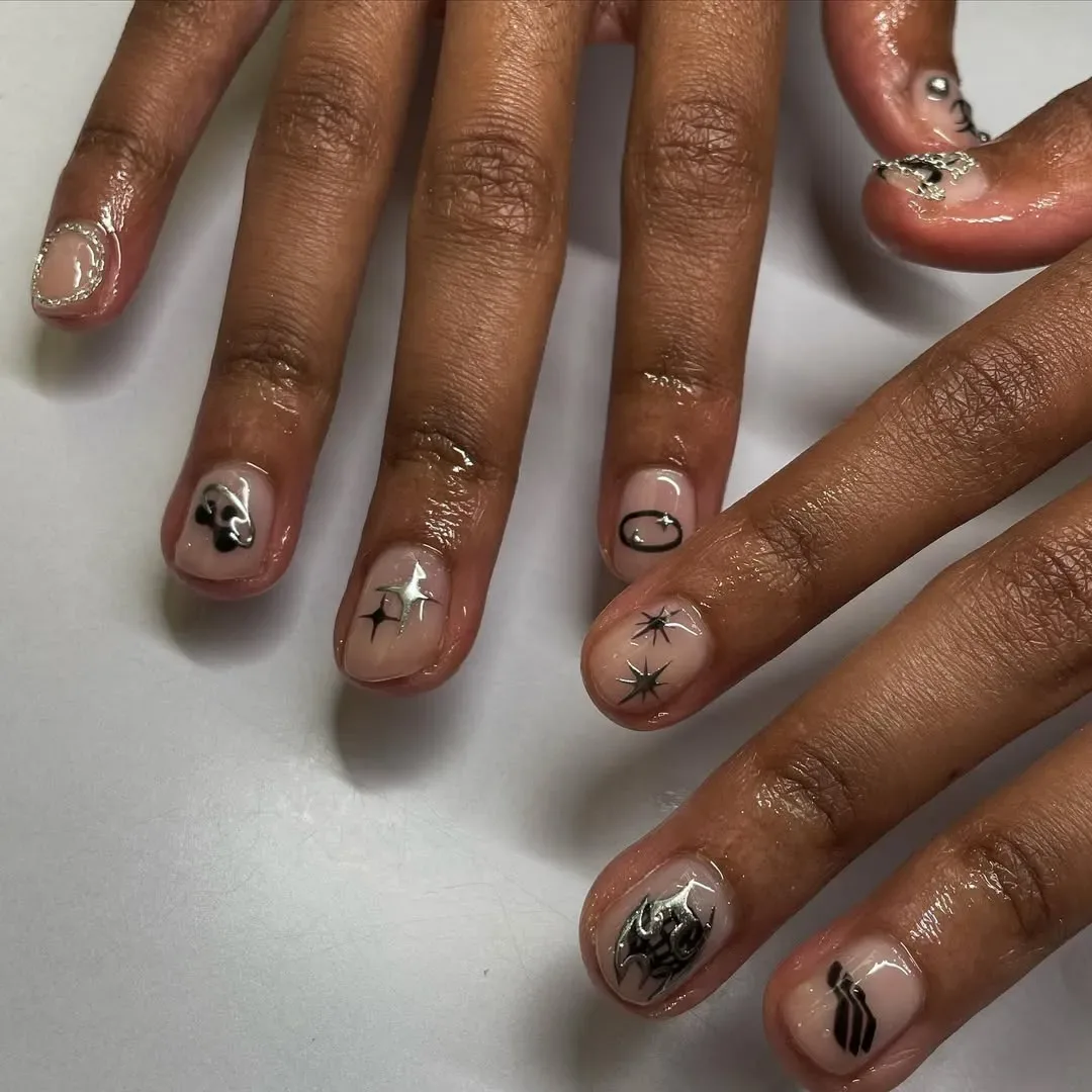 Persons hands shown with intricate nail art designs on their fingernails