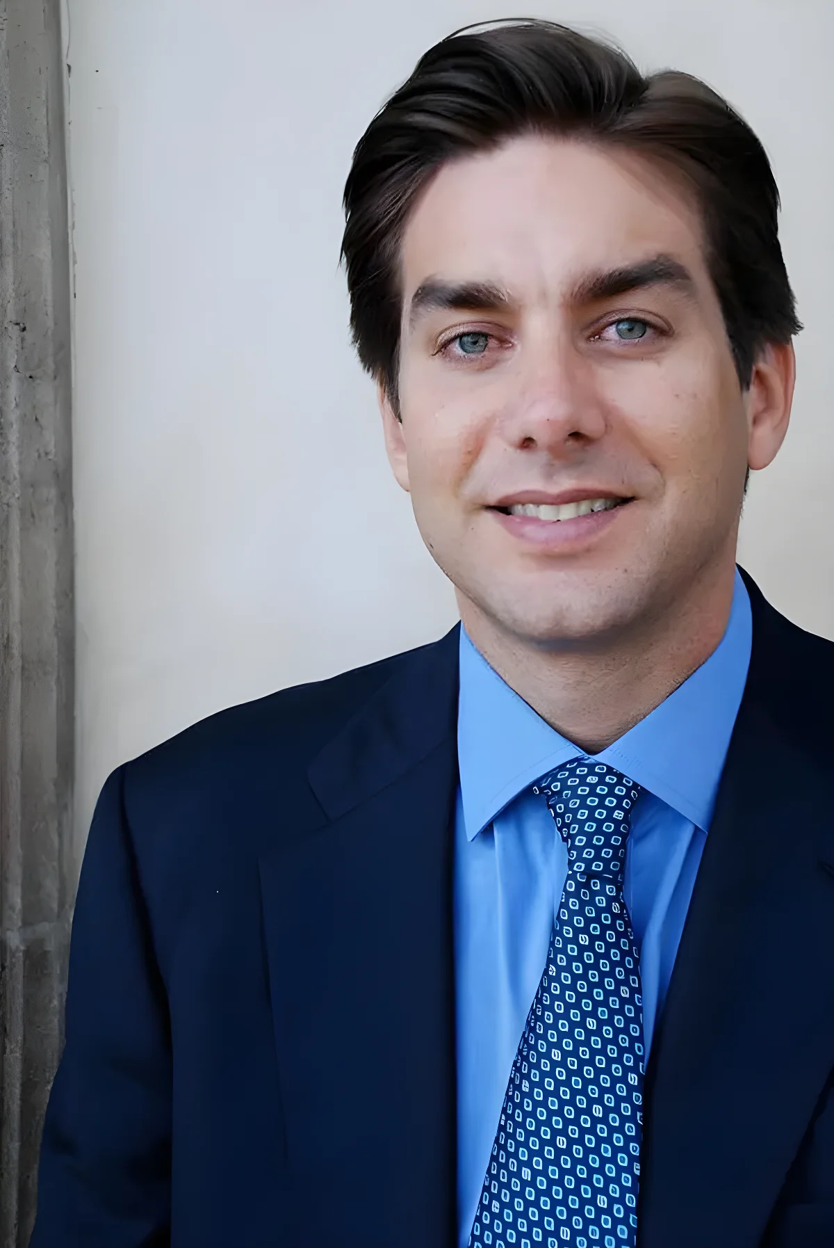 Portrait of Jason Galanis in a blue shirt, patterned tie, and dark jacket.