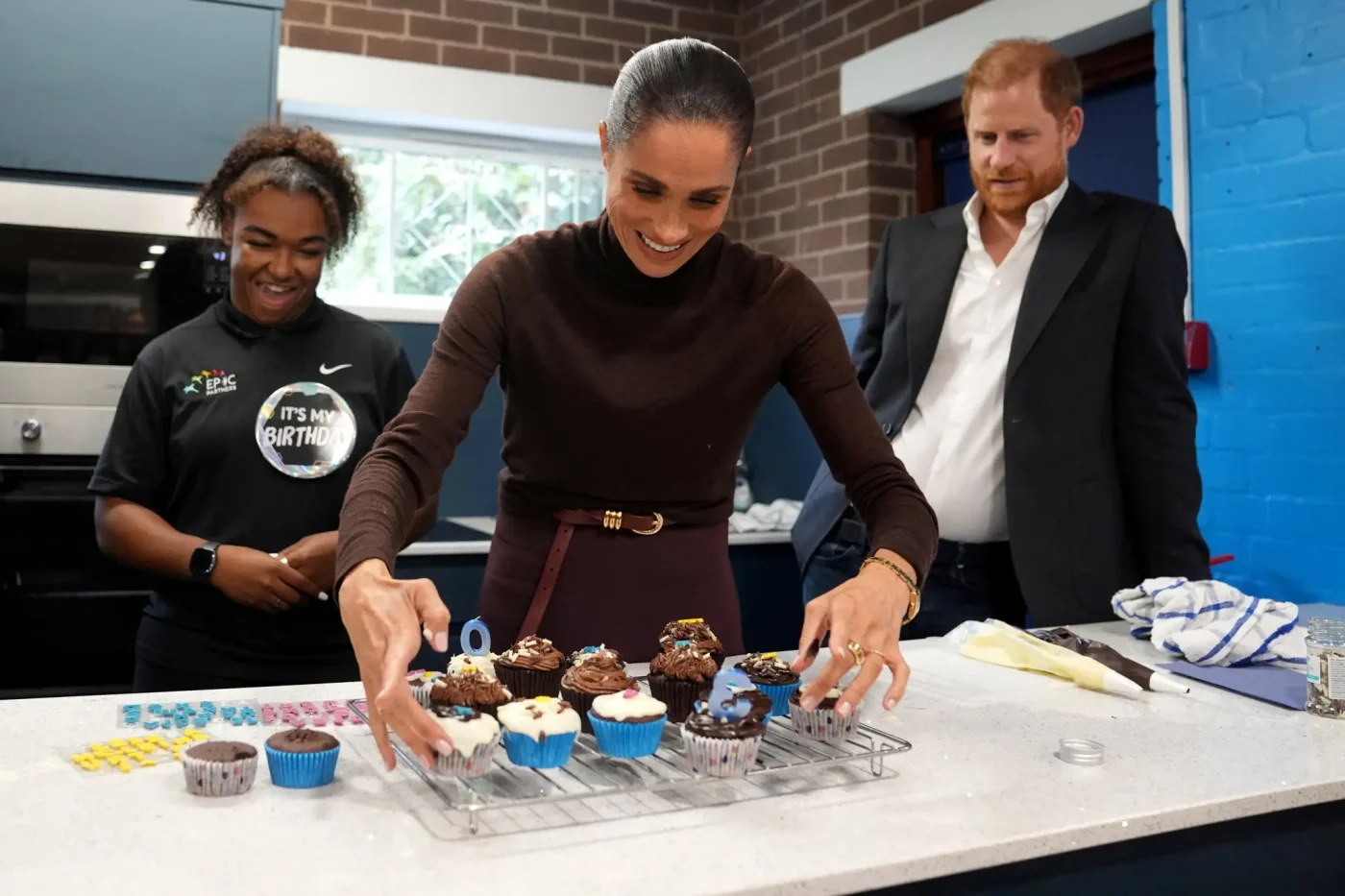 Prince Harry and Meghan, Duke and Duchess of Sussex, decorate birthday cupcakes at Epic Partners in Nottingham, England.