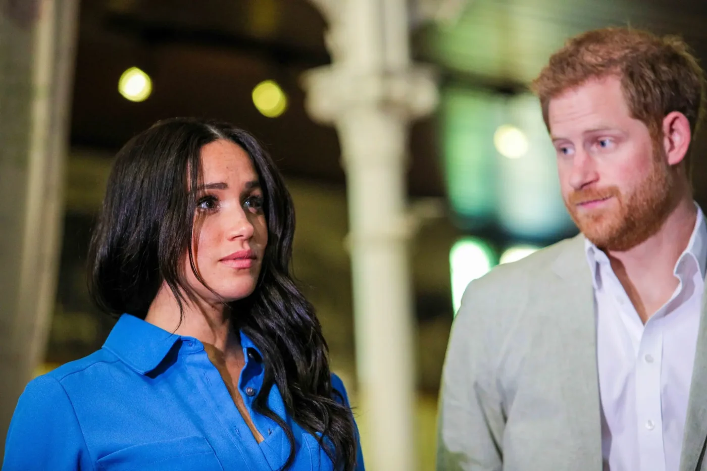 Prince Harry and Meghan Markle look on during an appearance.