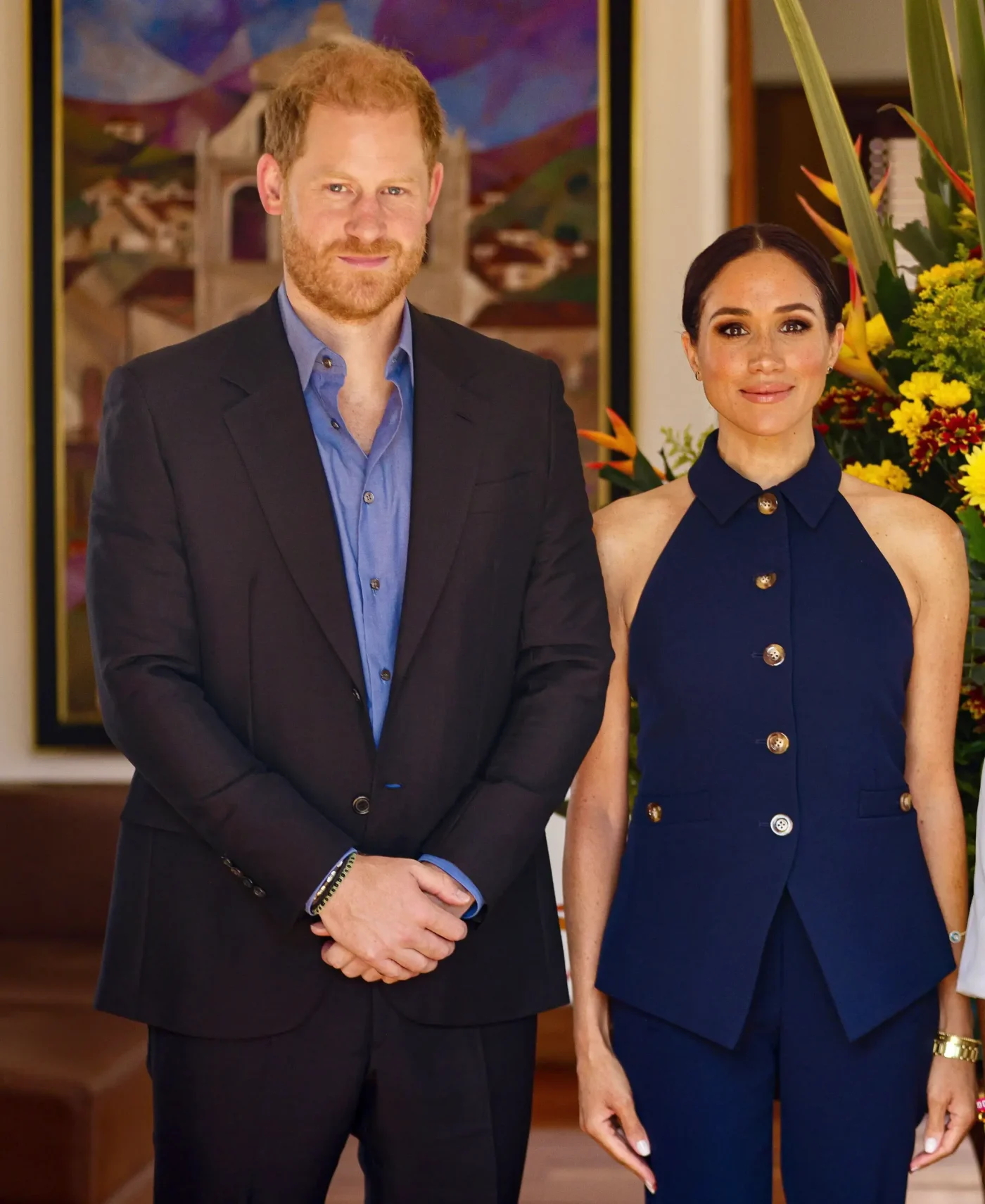 Prince Harry and Meghan Markle pose together indoors.
