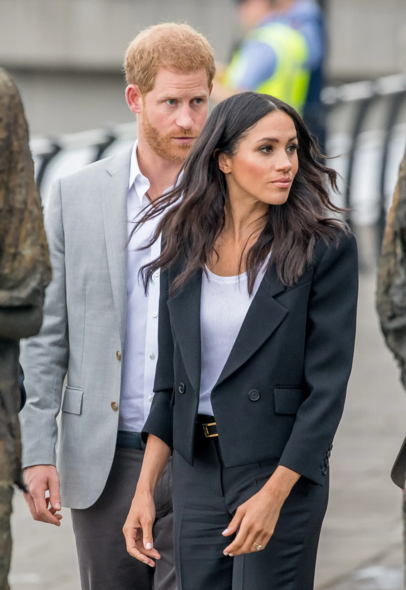 Prince Harry and Meghan Markle walk together outdoors.