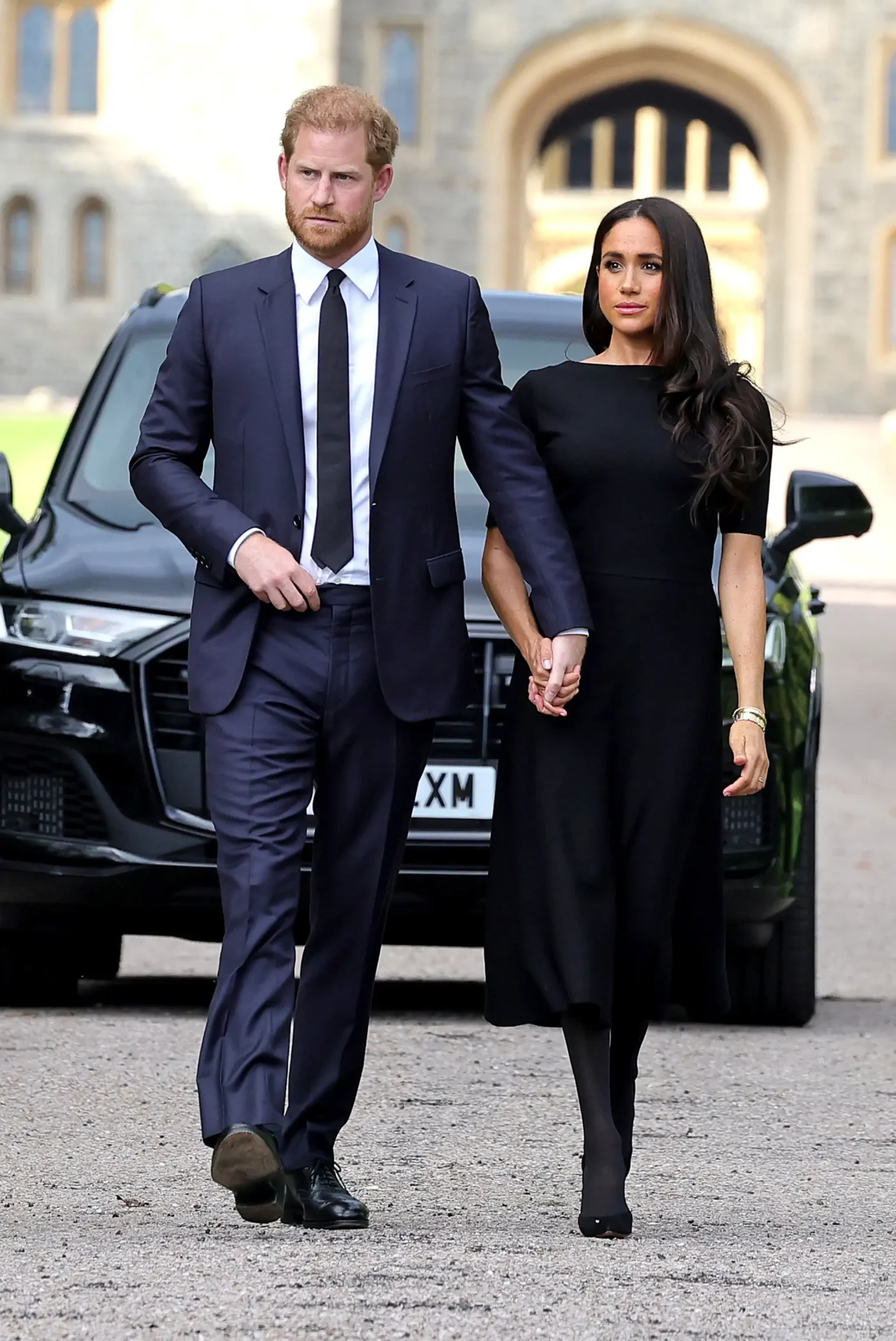 Prince Harry, Duke of Sussex, and Meghan, Duchess of Sussex walking together outside Windsor Castle.