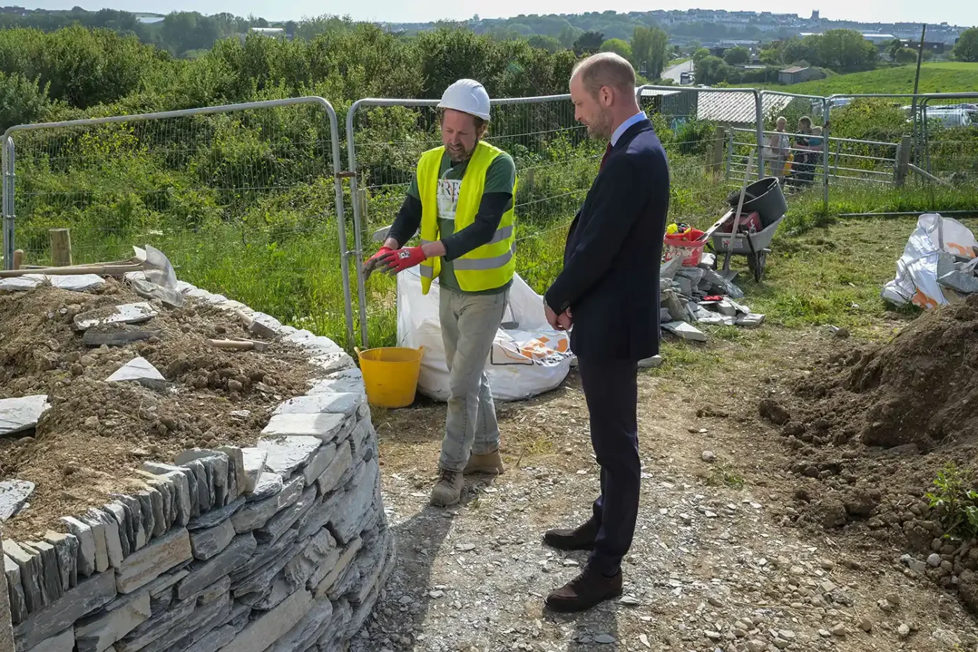 Prince William speaks with staff during his visit to Nansledan