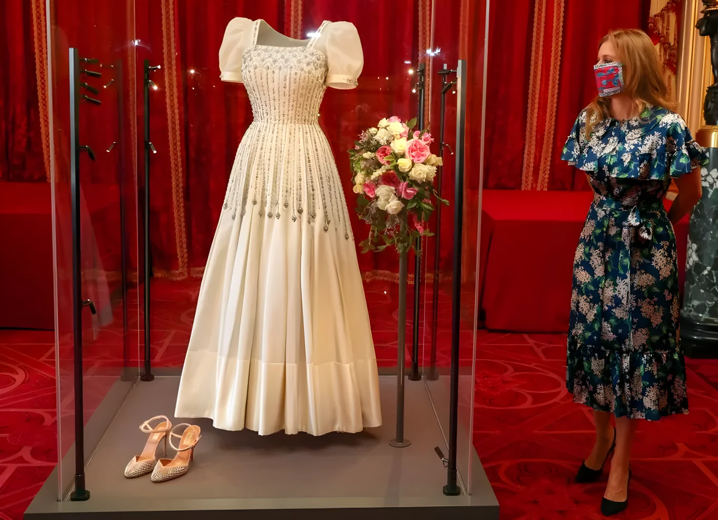 Princess Beatrice posing alongside her wedding dress as it goes on display at Windsor Castle