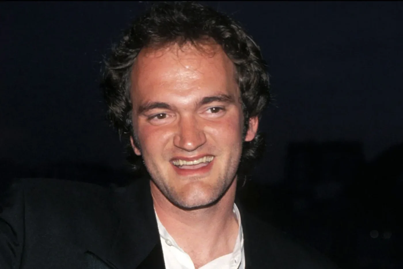Quentin Tarantino waves while holding the Palme d