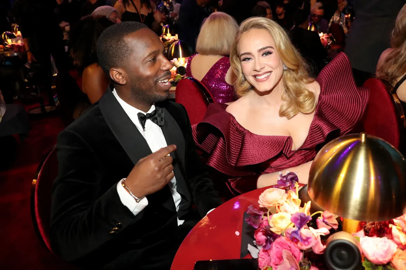 Rich Paul and Adele seated at a formal event smiling