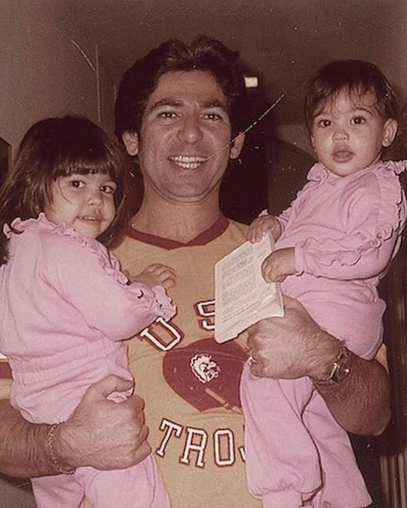 Robert Kardashian Sr. holding young Kourtney and Kim Kardashian.