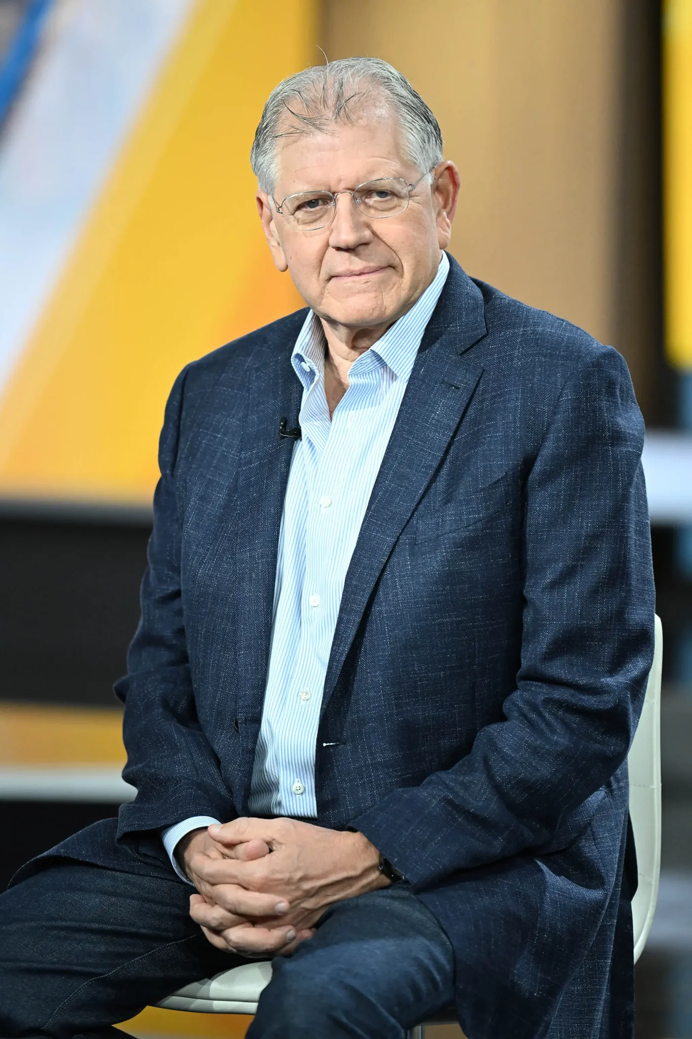 Robert Zemeckis sitting in a blue jacket and striped shirt.