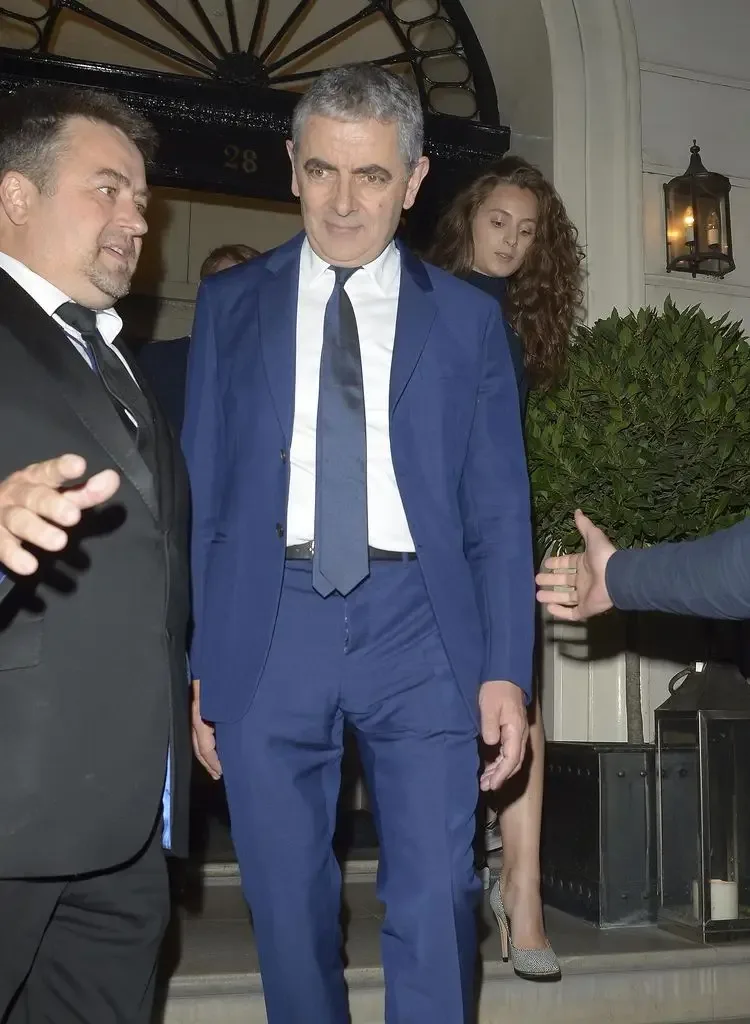 Rowan Atkinson and Lily Sastry leaving a hotel