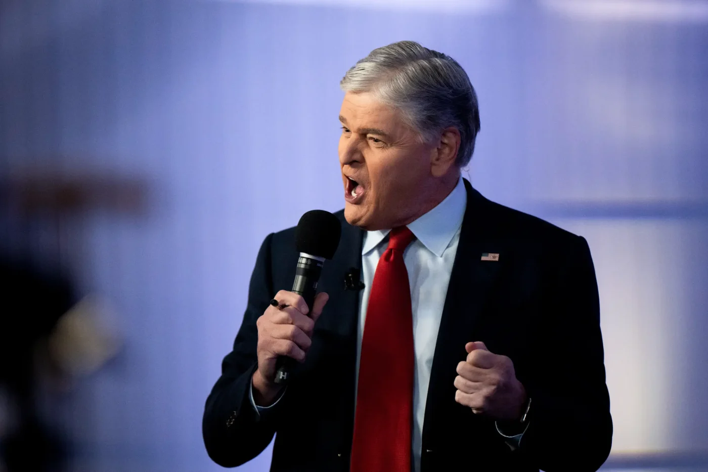 Sean Hannity speaking into a microphone during a town hall event.