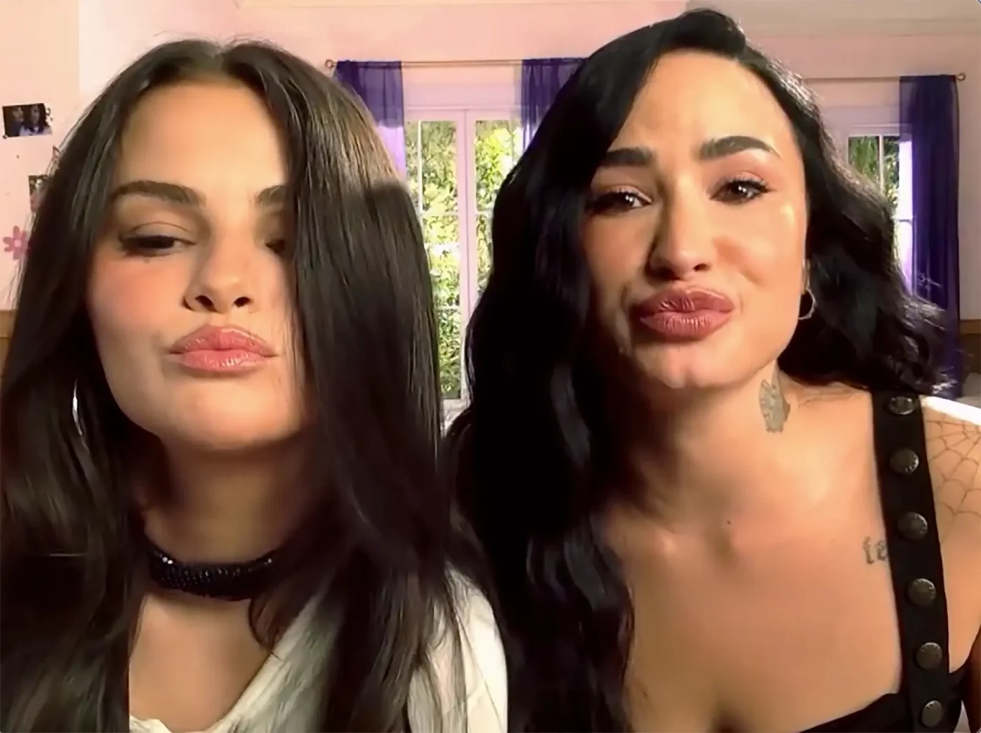Selena Gomez and Demi Lovato puckering their lips.
