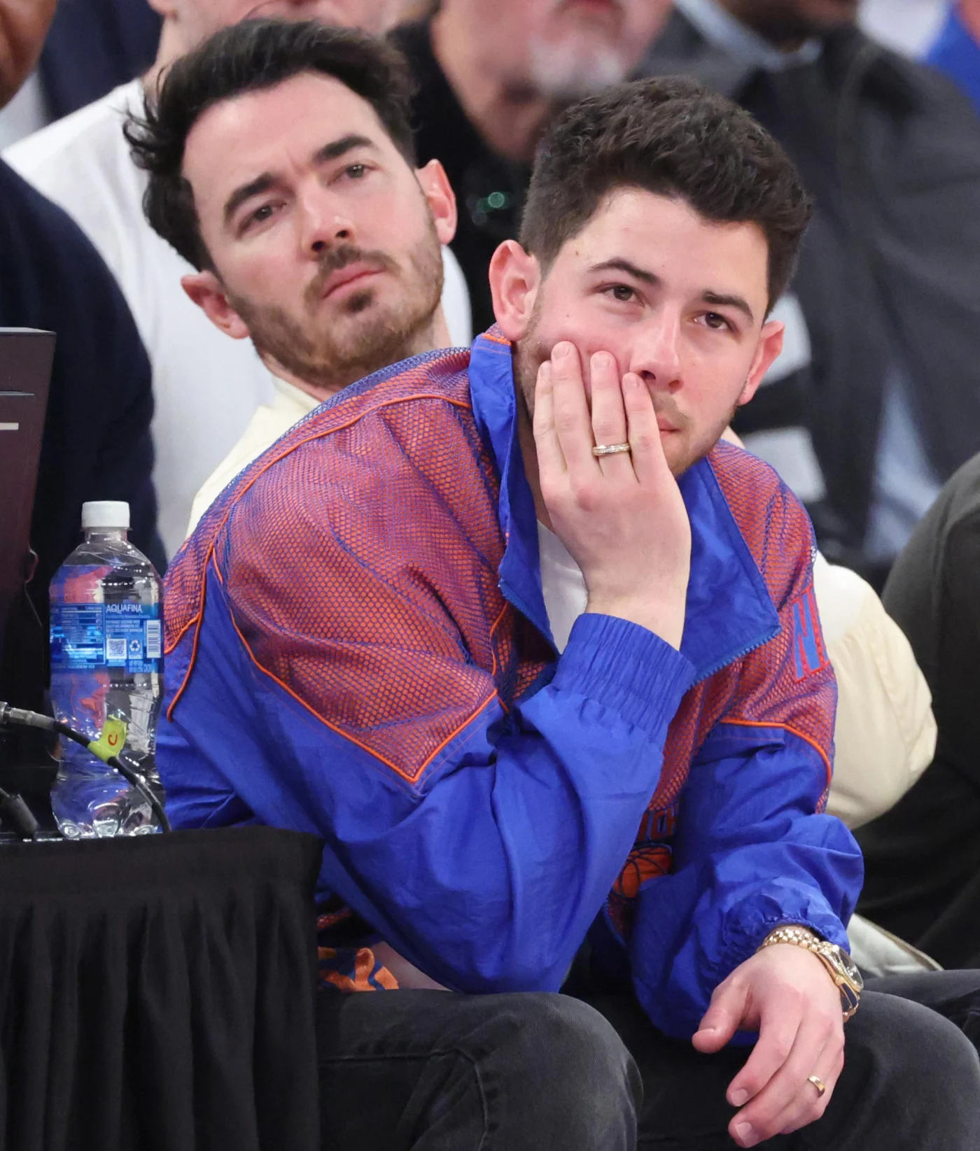 Singers Nick Jonas and Kevin Jonas sitting in the front row during the basketball game.