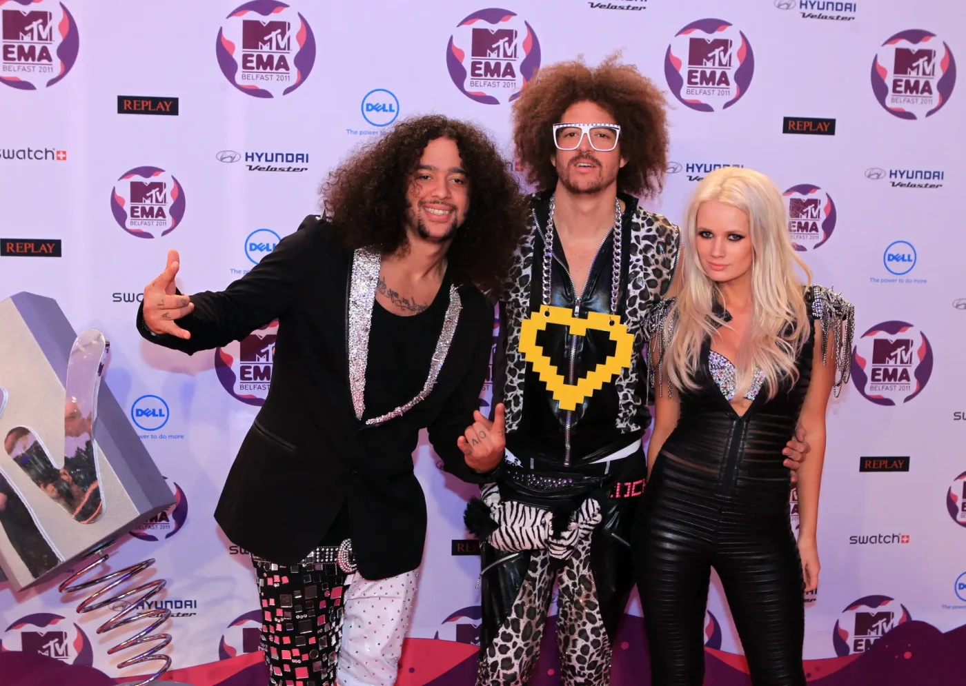 Skyblu and Redfoo of the US electro pop band LMFAO pose with British artist Lauren Bennett on the red carpet at the MTV European Music Awards.