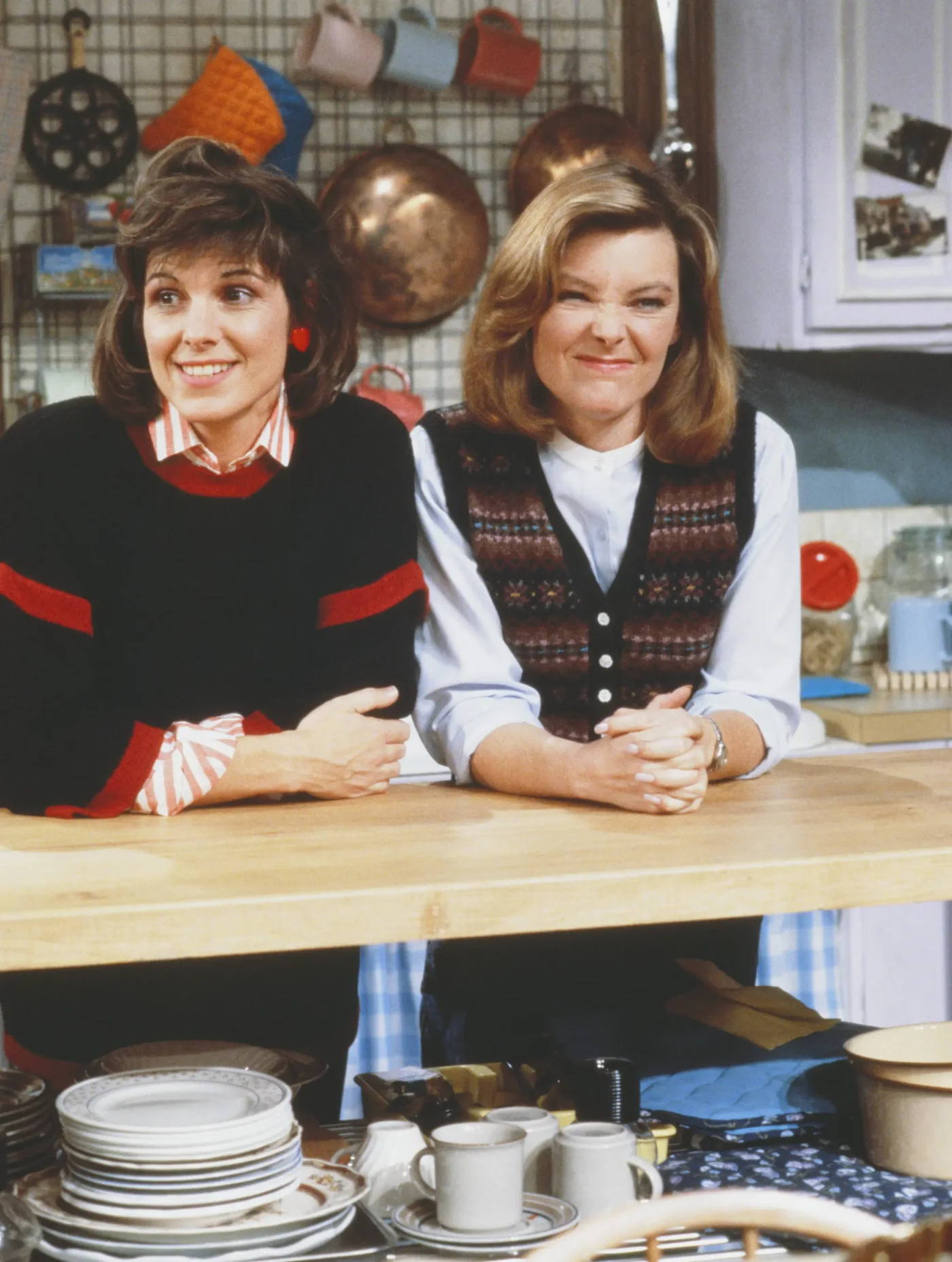 Susan Saint James as Kate McArdle and Jane Curtin as Allie Lowell lean against a kitchen counter in the television sitcom