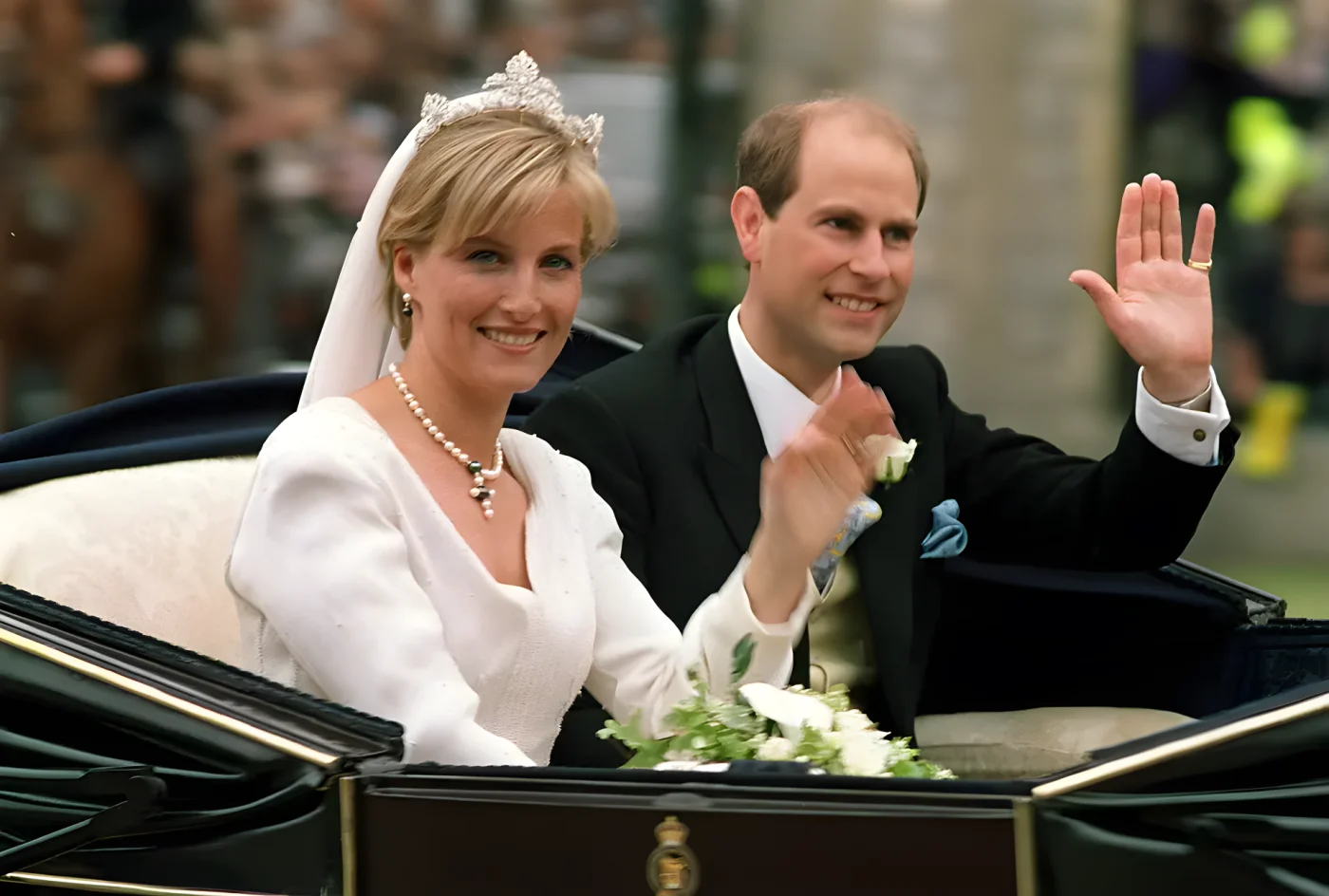 The newly-wed British royal couple Prince Edward (R) and Sophie Rhys-Jones greet wellwishers on their way from Windsor Castle after the wedding ceremony 19 June 1999. The royal couple took a brief ride through the historic town of Windsor.