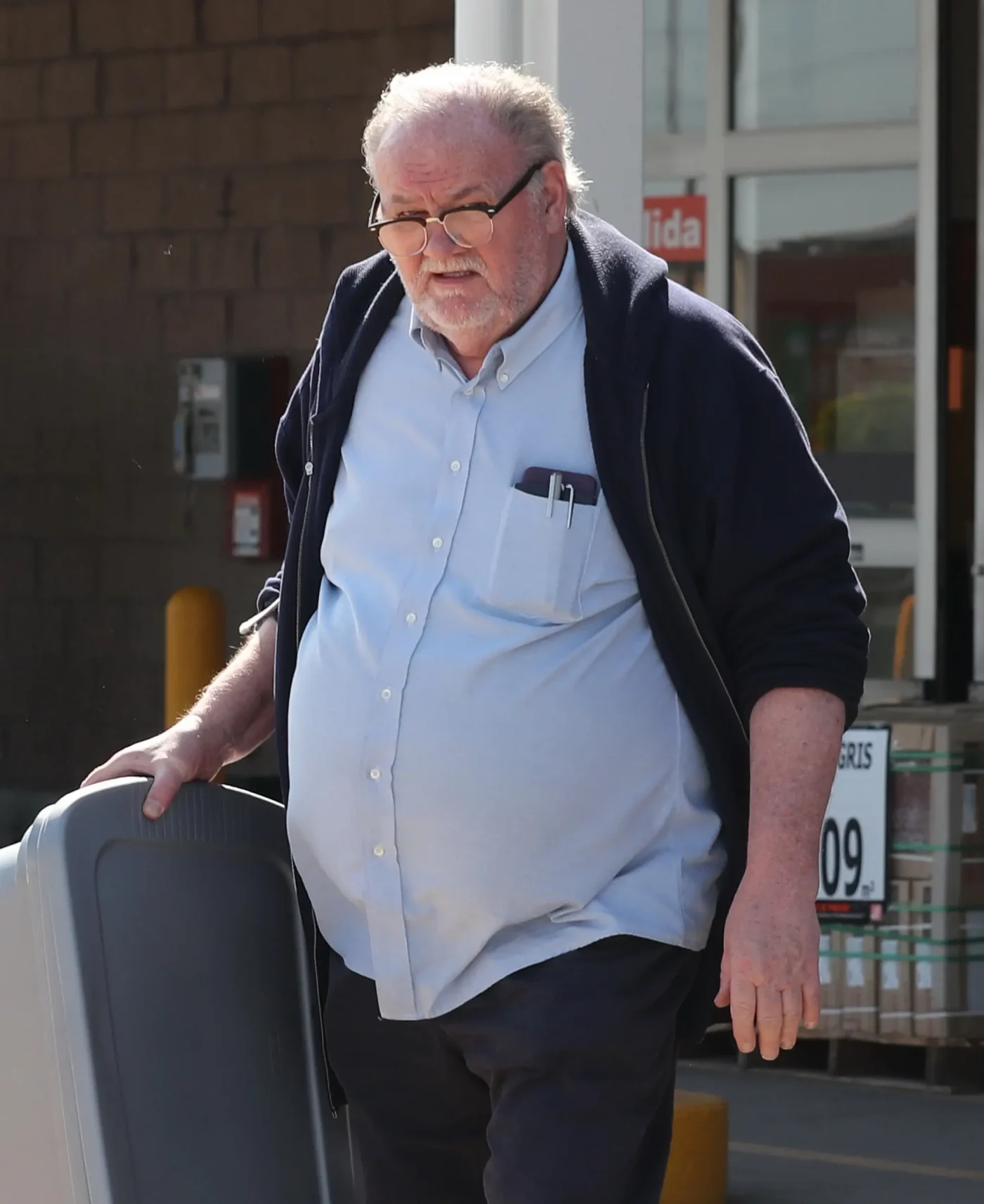 Thomas Markle carrying a plastic bin outside a store.