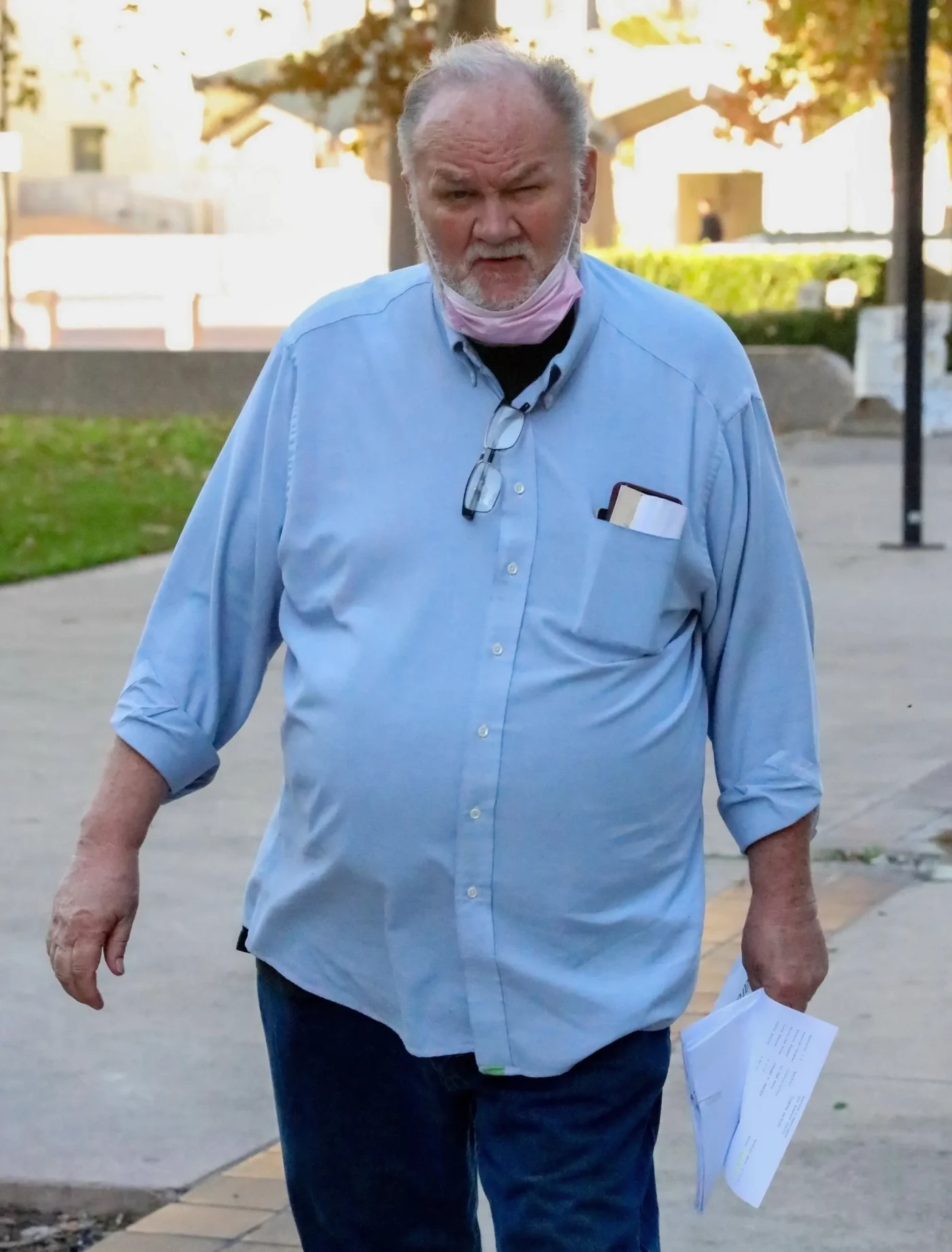 Thomas Markle walking outside the courthouse carrying legal documents.