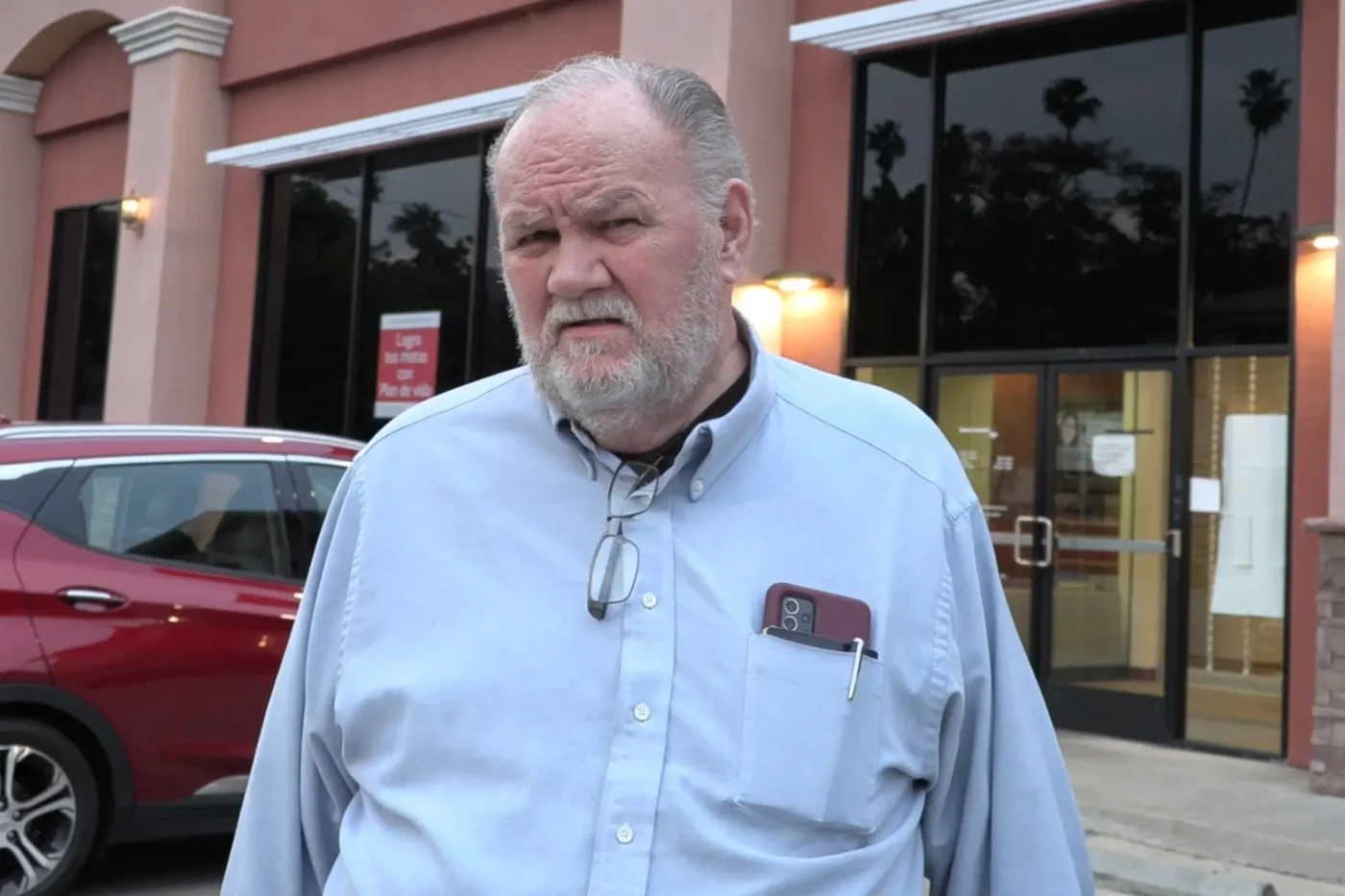 Thomas Markle wearing a light blue button-down shirt outside a building.