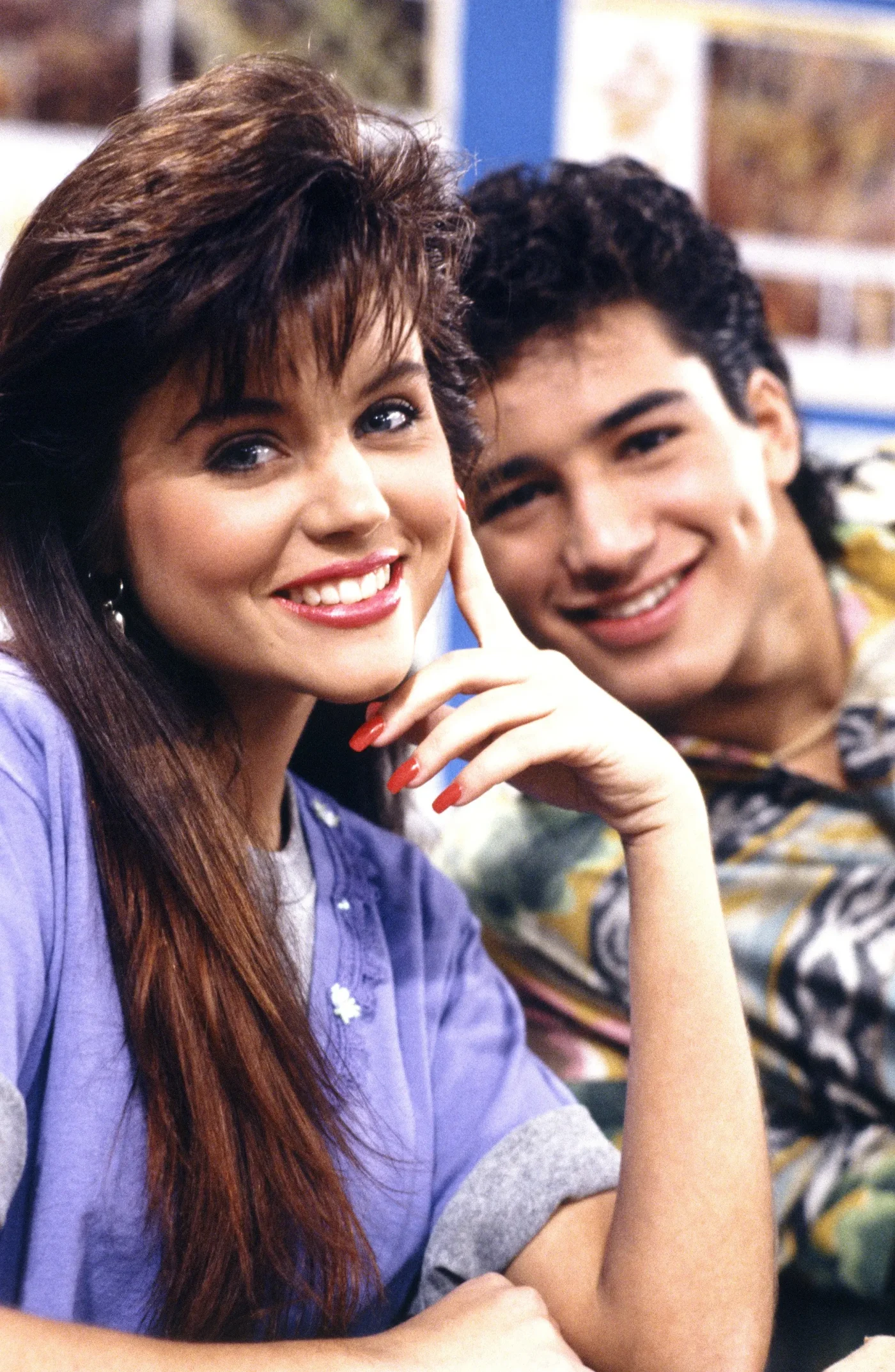 Tiffani Thiessen as Kelly Kapowski and Mario Lopez as A.C. Slater smiling in an episode of Saved by the Bell.