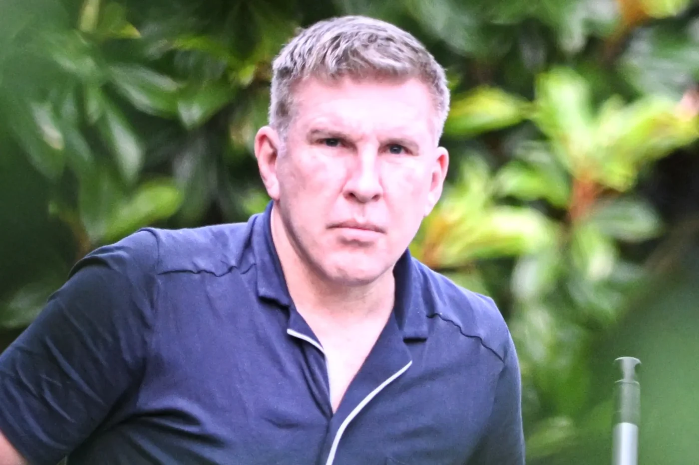 Todd Chrisley wearing a blue shirt outdoors.
