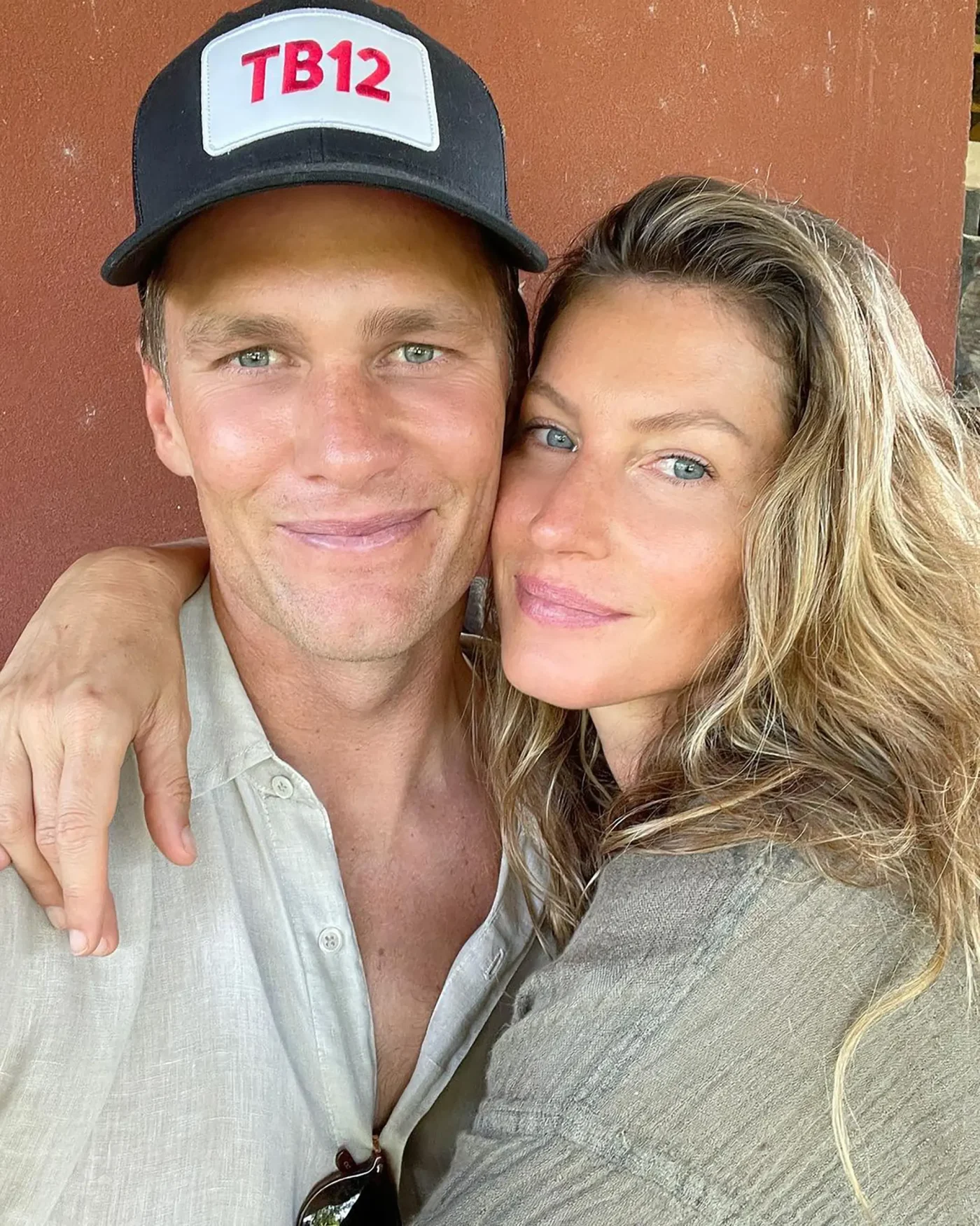 Tom Brady and Gisele Bündchen posing closely together with smiles.