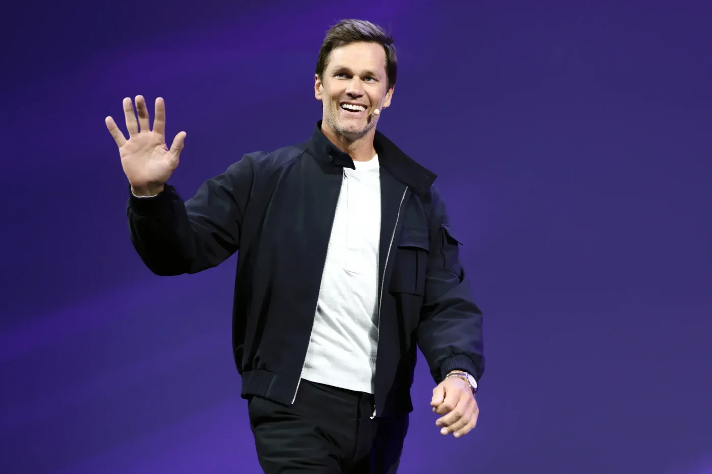 Tom Brady smiles and waves on stage at the OMR Festival.