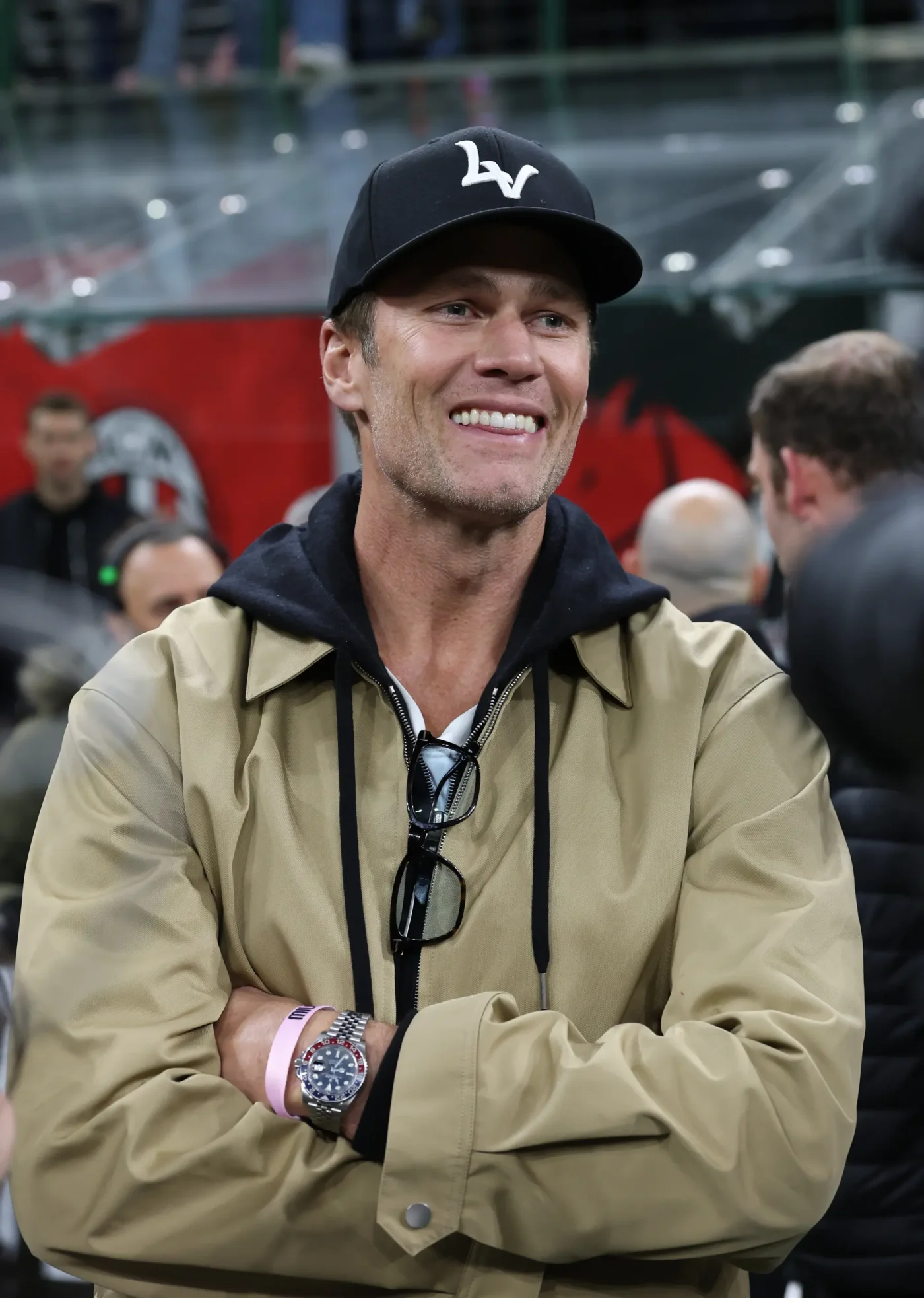 Tom Brady smiling while attending a soccer match.