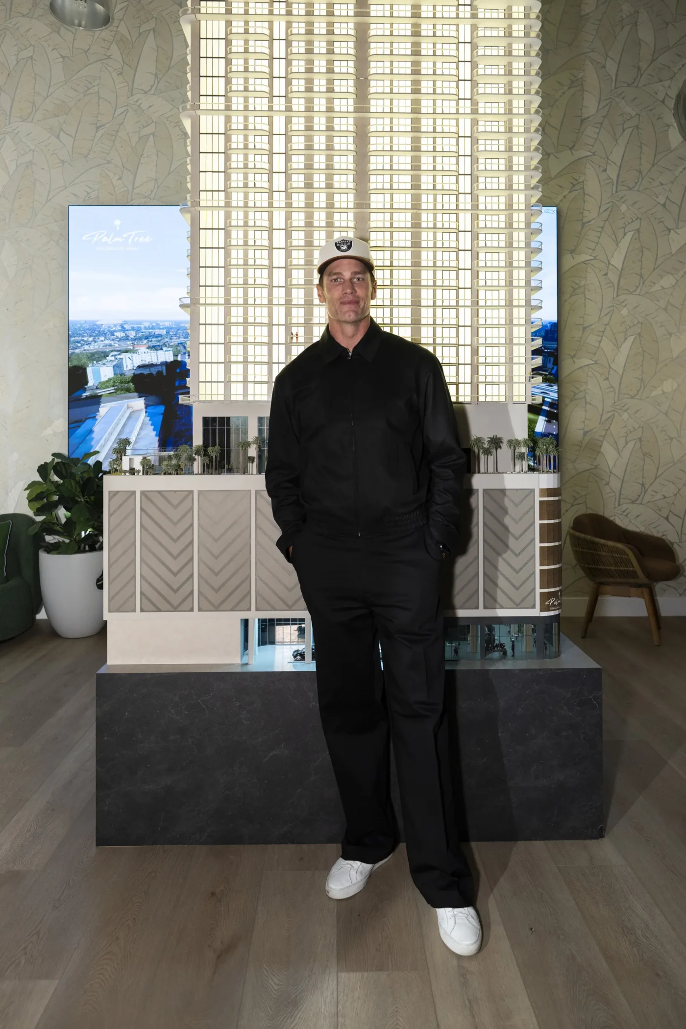 Tom Brady stands in front of a model of the Palm Tree Residences Miami at a sales gallery dinner.