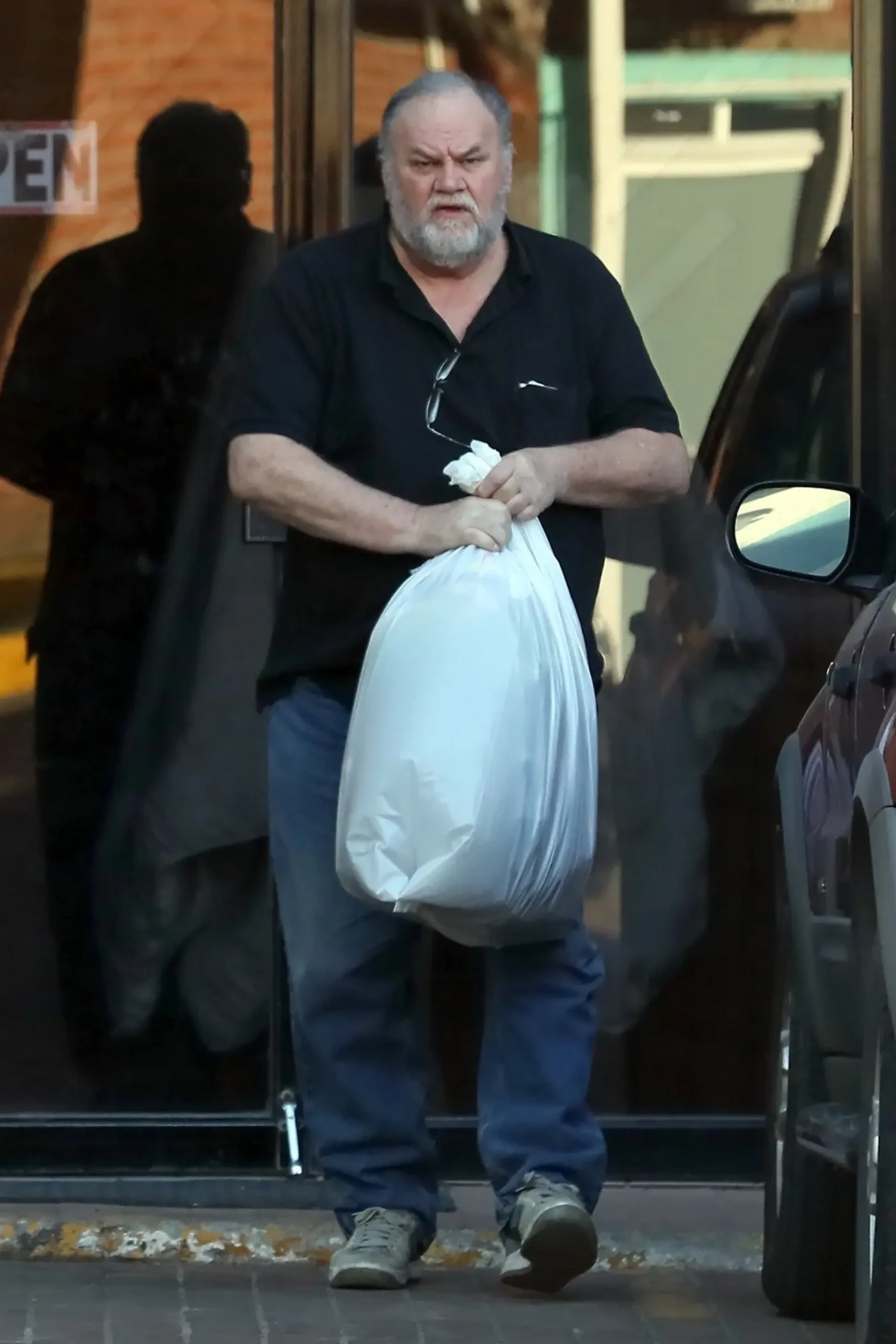 Tom Markle carrying a large white bag while running errands.