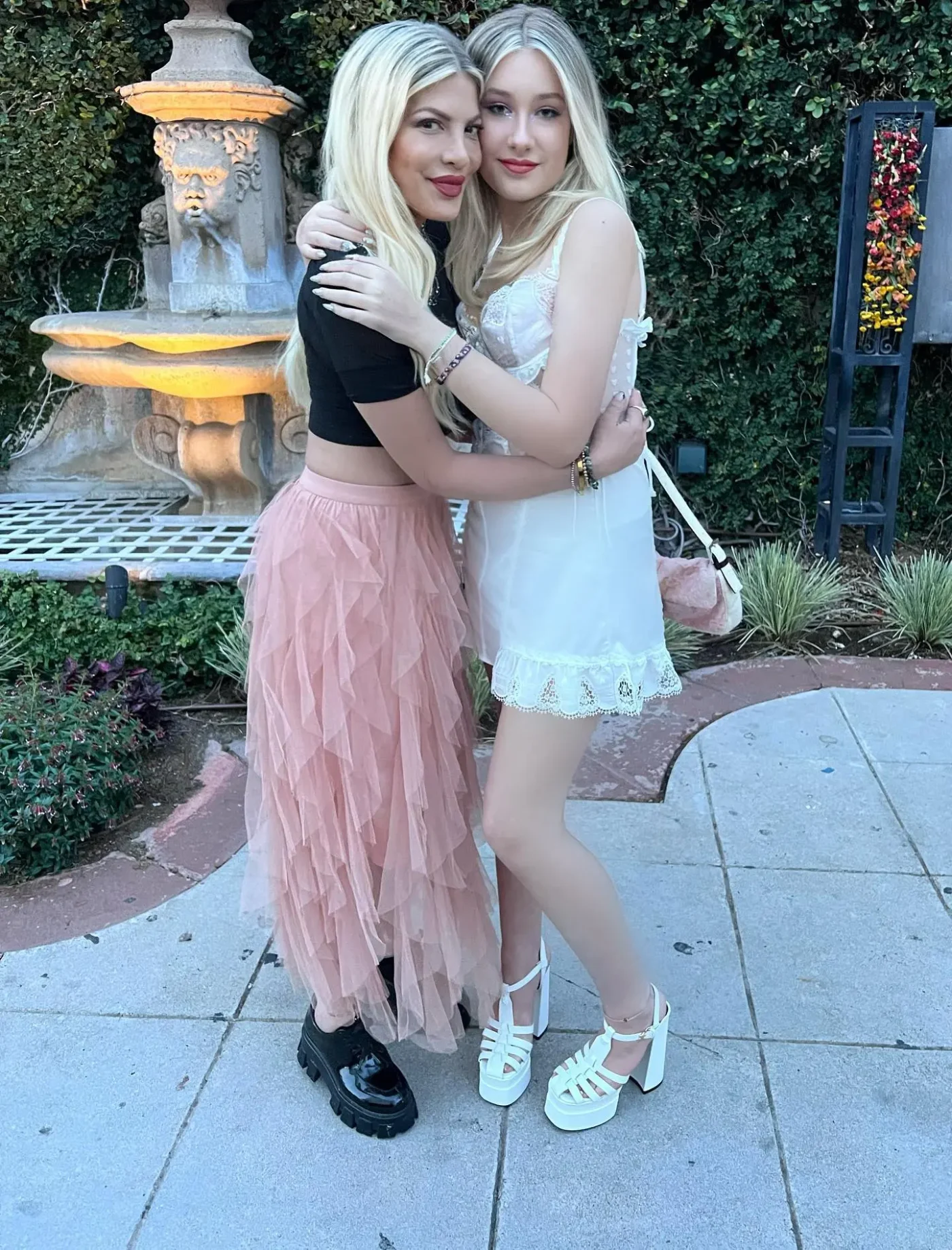 Tori Spelling and her daughter Stella hugging outdoors.