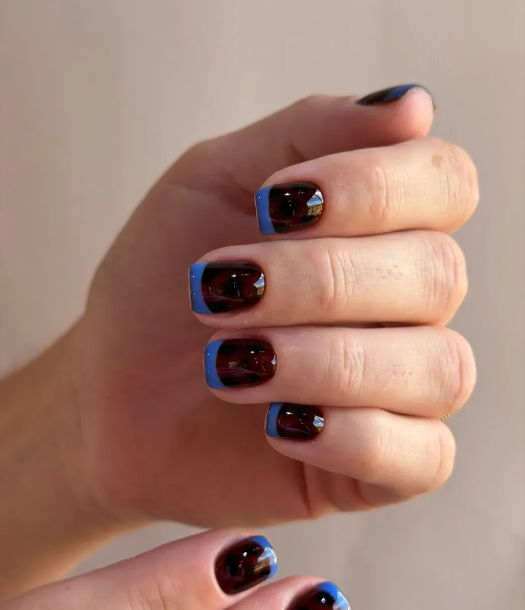 Tortoiseshell nails with bright blue French tips