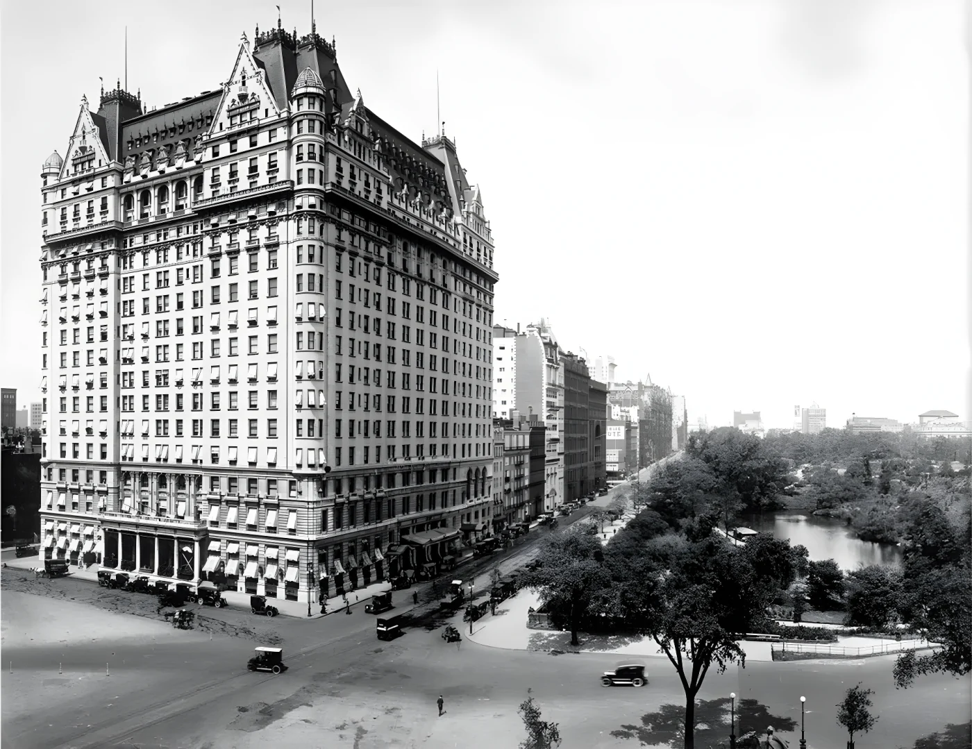View, looking west on 59th street, of the east and north facades of the Plaza Hotel, early twentieth century. The southern end of Central Park, with various vehicular traffic, is also visible