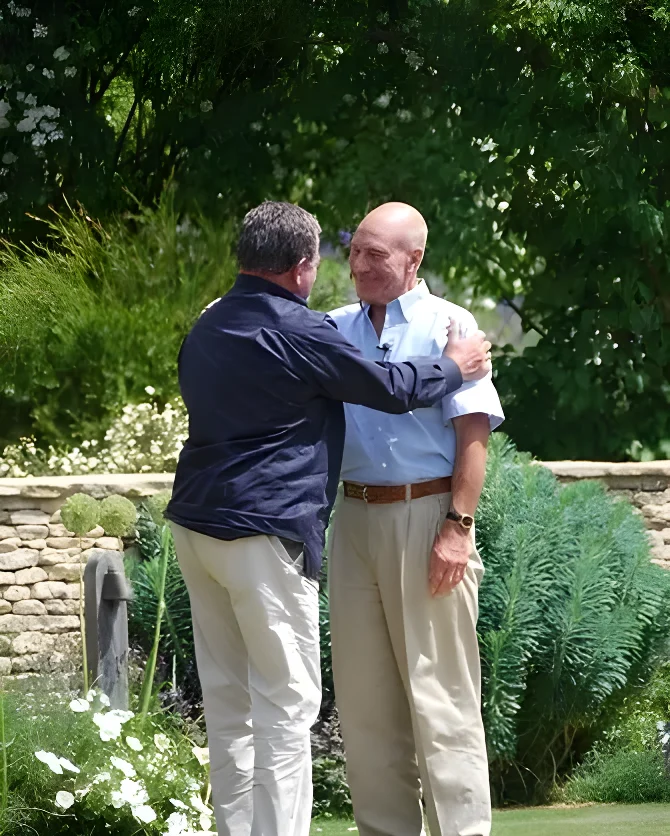 William Shatner hugging Patrick Stewart outdoors.